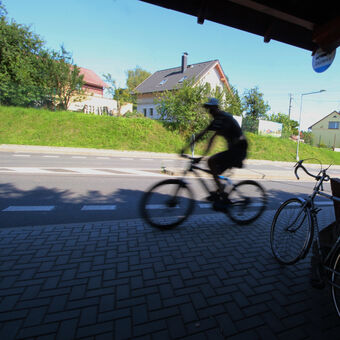 Cyklista projíždí autobusovou zastávkou v Metylovicích na Vrchovině