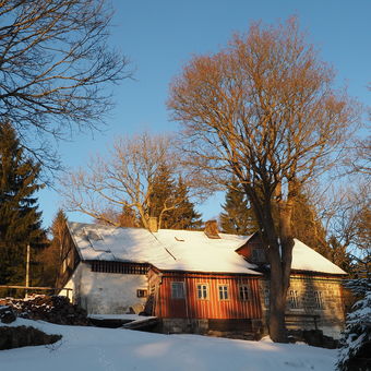 Zimní chata při západu slunce.