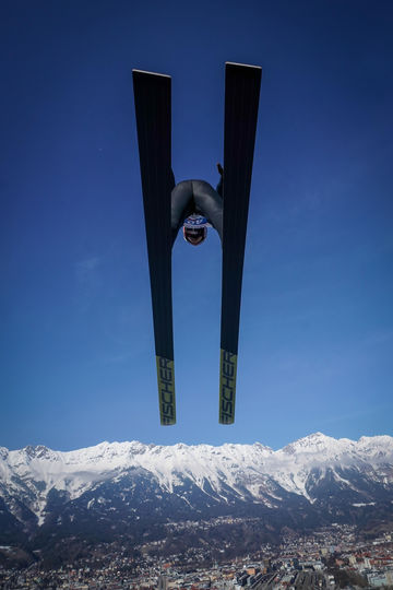 tomasz-markowski-sony-alpha-9-looking-up-at-a-ski-jumper-as-he-passes-overhead-against-a-deep-blue-sky | Megapixel