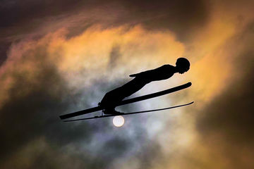 tomasz-markowski-sony-alpha-9-ski-jumper-sideways-on-against-an-orange-cloudy-sun | Megapixel